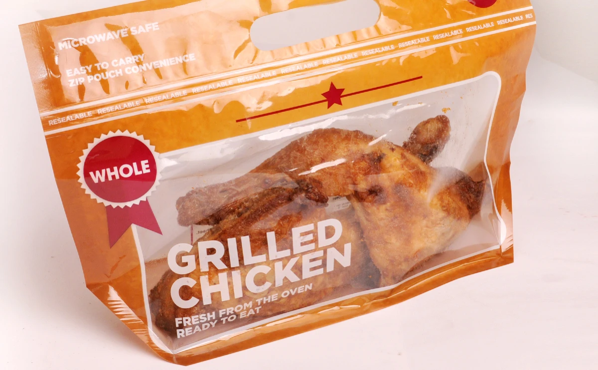 "Resealable microwave bag for chicken with whole grilled chicken visible, showcasing the ease and convenience of JC Packaging's food packaging solutions."