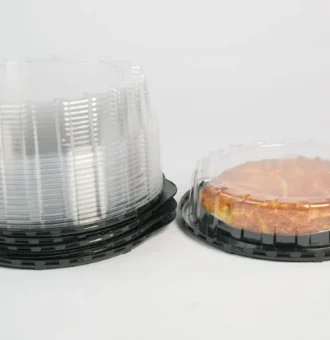 "Stack of JC Packaging's clear containers for cakes and tarts on black bases, featuring a delicious tart in a transparent package, ready for display."