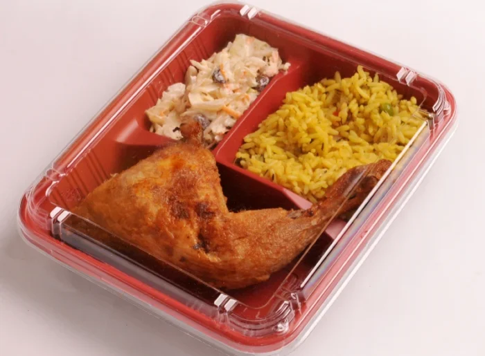 "A fully prepared meal in a clamshell meal tray featuring roasted chicken, pasta salad, and rice, from JC Packaging."